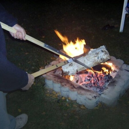 Placing a log in a fire with a Campfire Tongs log grabber